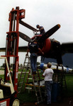 Removing the prop from the damaged engine of the B-24.  I had the job of helping to remove the prop dome.  I was repaid with about a half gallon of oil being dumped on me when the dome finally came loose.