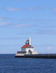 The South Pier Light at the Duluth Harbor Entrance.  This lighthouse displays a steady green light and also houses a restored fog signal in the attached fog signal building.