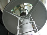 This photo is taken standing in the watch room, just below the lantern.  From this perspective you are looking up into the fresnel lens itself.  You can see that the light is currently powered by an electric light bulb.  It was originally powered with a kerosene lamp.